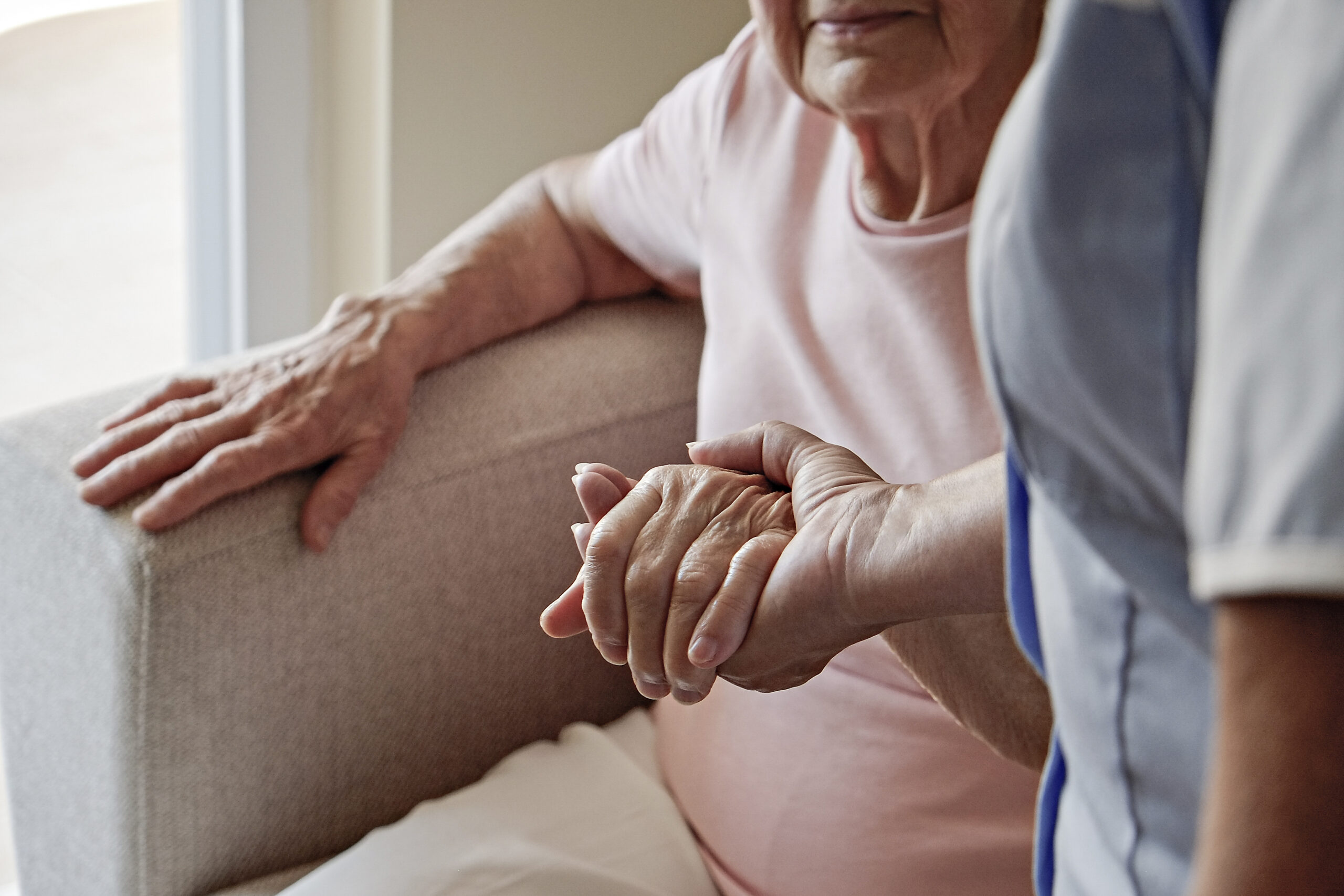 a nurse assisting a woman getting up