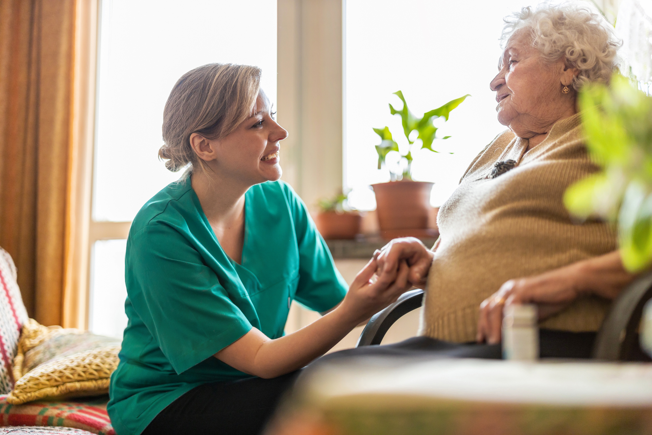 Health visitor talking to a senior woman during home visit